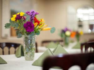 A vase of flowers on a table in the dining room at Mckinley Park