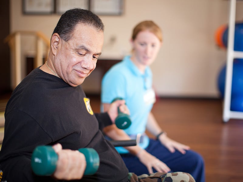 A physical therapist working with an elderly man at Mckinley Park