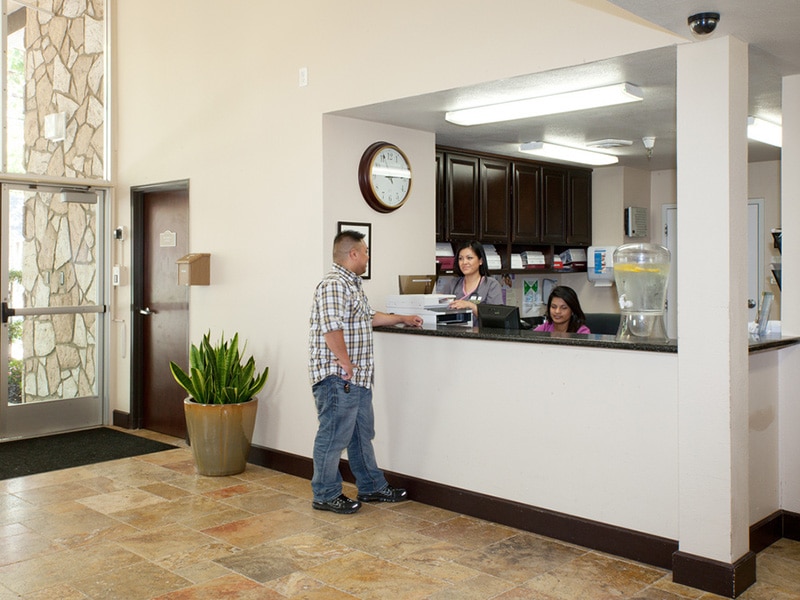 A man talking to the front desk workers at Mckinley Park