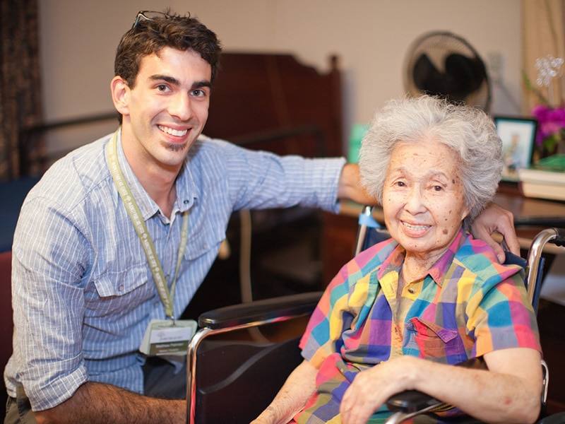 An employee with an elderly woman smiling at Mckinley Park